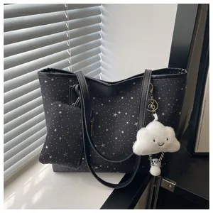 Detail of black starry tote bag with matching pouch and white cloud plush charm