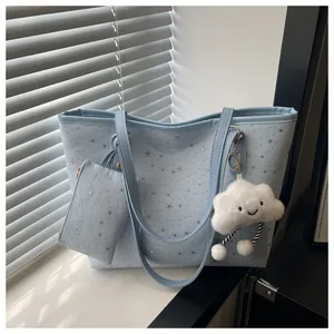Close-up of light blue tote bag set featuring silver stars and a cute cloud charm