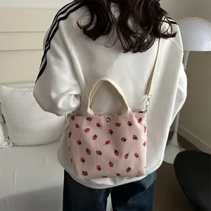 Pink corduroy strawberry print tote bag with adjustable canvas shoulder strap and top handles