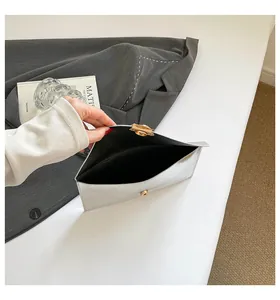 Vue intérieure de la pochette enveloppe argentée avec détails texturés et boucle dorée