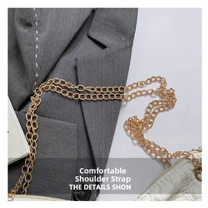 Close-up of golden metal chain strap on quilted cream white puffer shoulder bag