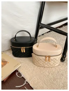 Close-up of quilted embroidery and dual metal zippers on leather bucket vanity bags