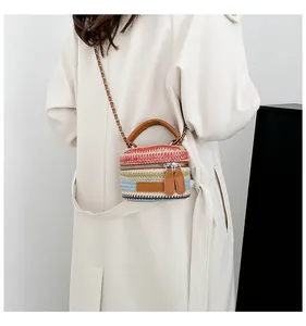 Detail der farbenfroh gestreiften Stroh-Mini-Eimertasche mit Kettenriemen und Ledergriff