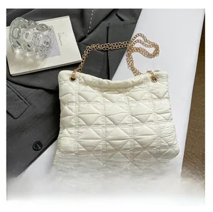 Detail view of white quilted puffer shoulder bag with elegant gold chain strap