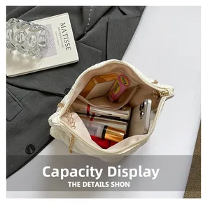 Spacious interior of white quilted puffy bag showing storage for cosmetics and phone