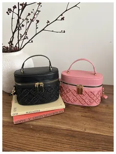 Detail of embroidered quilted box bags in black and pink with crown logo and gold hardware