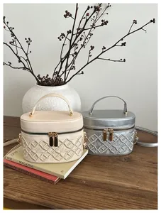 Detailed close-up of quilted embroidery and crown motif on vintage bucket handbag
