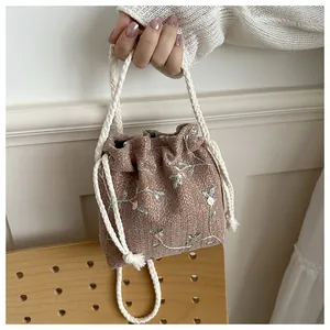 Detailed macro view of pink embroidered floral pattern on woven bucket bag fabric