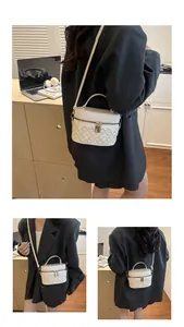 Close-up of cream-white bucket bag with quilted embossing and gold metal zippers