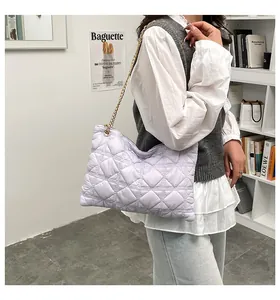 Detail of lavender quilted puffer bag with golden chain strap and soft pillow shape texture