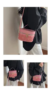 Detail of pink quilted box bag with dual metal zippers and adjustable shoulder strap