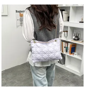 Close-up of lavender quilted puffer bag featuring a gold chain strap and smooth texture