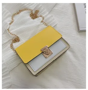 Detail view of contrast color crossbody bag with gold chain and metal lock closure