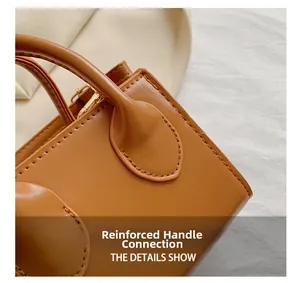 Macro shot of reinforced handle connection on brown leather crossbody bag