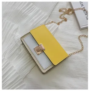 Detail of color-block crossbody bag with yellow flap and golden chain strap on magazine