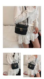 Detail of black quilted bucket bag with gold zippers and detachable shoulder strap