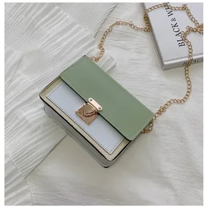 Detail shot of a minimalist color-block crossbody bag with gold buckle and chain strap