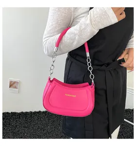 Detailansicht der rosafarbenen Mondsichel-Tasche mit Silberkette und Goldaufdruck