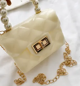 Detail view of mini cream pearl handle bag with quilted texture and gold turn-lock