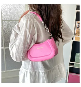 Leuchtend rosa Achseltasche aus PU-Leder mit silberner Kette an einem Model