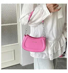 Detail der pinkfarbenen Handtasche mit silberner Metallkette und Logo-Schriftzug