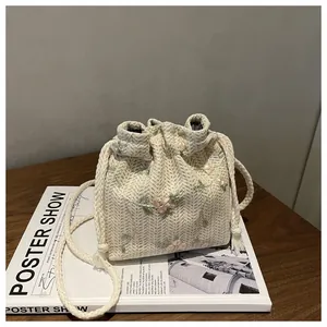 Straw bucket bag with floral embroidery and drawstring closure for beach casual style