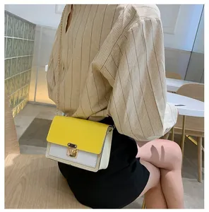 Lifestyle view of yellow and white crossbody bag with gold chain and metal clasp