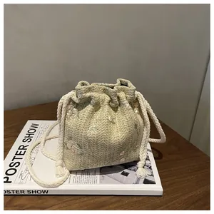 Straw bucket bag with floral embroidery and white drawstring strap for women