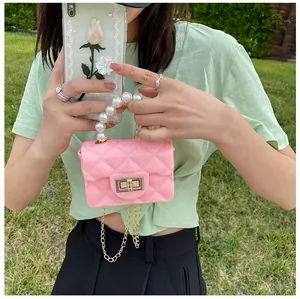 Detail of pink mini quilted jelly bag featuring large pearl handle and gold lock