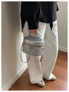 Detail of silver quilted makeup bag with gold hardware and detachable shoulder strap