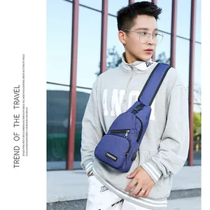 Men's blue oxford chest bag with USB charging port shown on model in urban setting