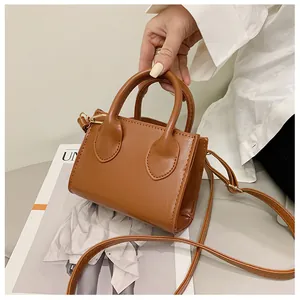 Detailed shot of brown PU leather handbag featuring neat stitching and dual handles