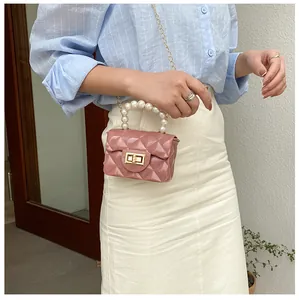 Detailed close-up of pink mini jelly bag with diamond quilting and pearl handle strap