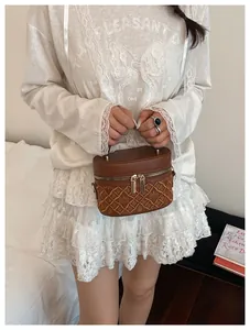 Brown bucket style makeup bag with quilted pattern shown on a model in lace dress