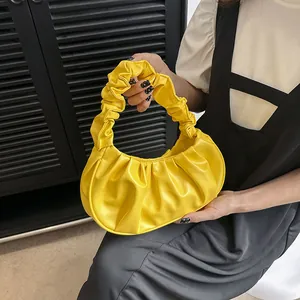 Primer plano del bolso nube plisado amarillo brillante en cuero PU con texturas detalladas