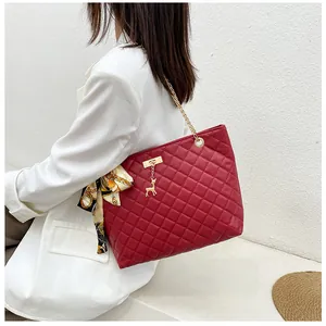 Red quilted chain handbag with a golden deer charm and decorative silk scarf