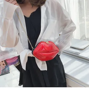 Detailed view of red lip-shaped crossbody bag with glossy finish and gold chain strap