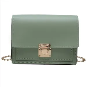 Fashionable green crossbody bag with gold lock and metal chain strap on white background