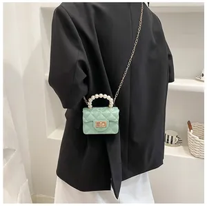Mint green quilted mini bag featuring a pearl handle and gold chain shoulder strap