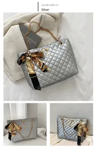 Silver quilted tote bag featuring metallic finish with gold chain straps and charm