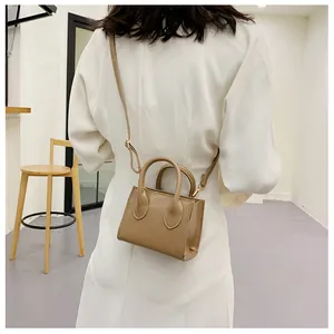 Micro khaki tote bag in PU leather shown on model for size and scale reference