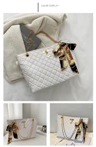 Detail of white quilted tote bag with gold chain strap, deer pendant and silk scarf