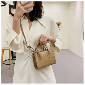 Detail of a khaki PU leather mini handbag with gold metal buckles and adjustable strap