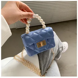 Macro detail of blue quilted jelly bag featuring a pearl handle and gold twist lock