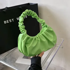 Primer plano detallado del bolso nube verde brillante con textura fruncida y asa plisada