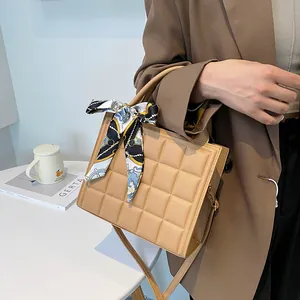 Beige checkered leather handbag with silk scarf handle and adjustable crossbody strap