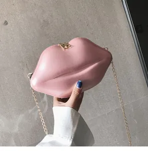 Pink lip-shaped crossbody bag featuring shiny patent leather and golden chain detail