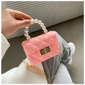 Detailed close-up of pink jelly mini bag with quilted pattern and pearl top handle
