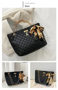 Detail of black quilted tote bag with golden chain strap and gold deer charm accessory