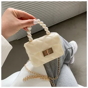 Detailed macro view of mini off-white jelly bag with pearl handle and golden rotary lock